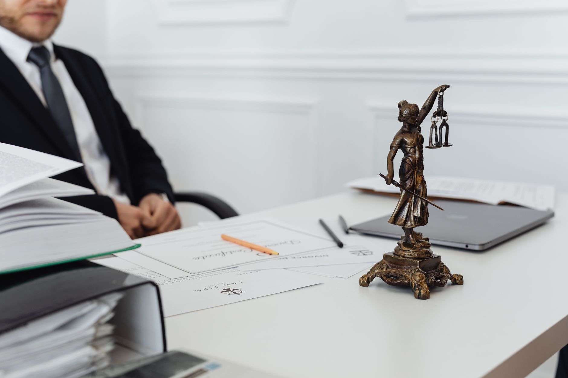 A legal professional's workspace with Lady Justice statue and documents