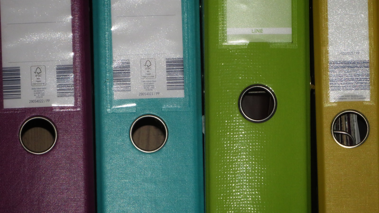 Row of colour-coded document binders on a shelf – official paperwork