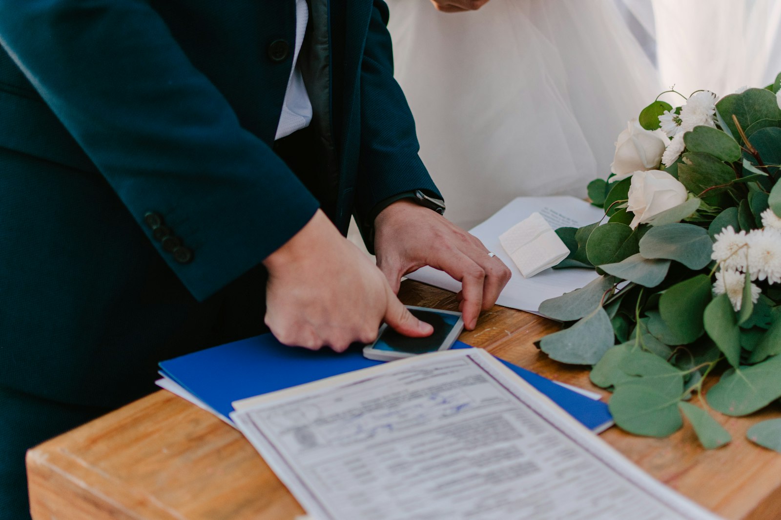 Couple signing marriage certificate with bouquet – searching for a record